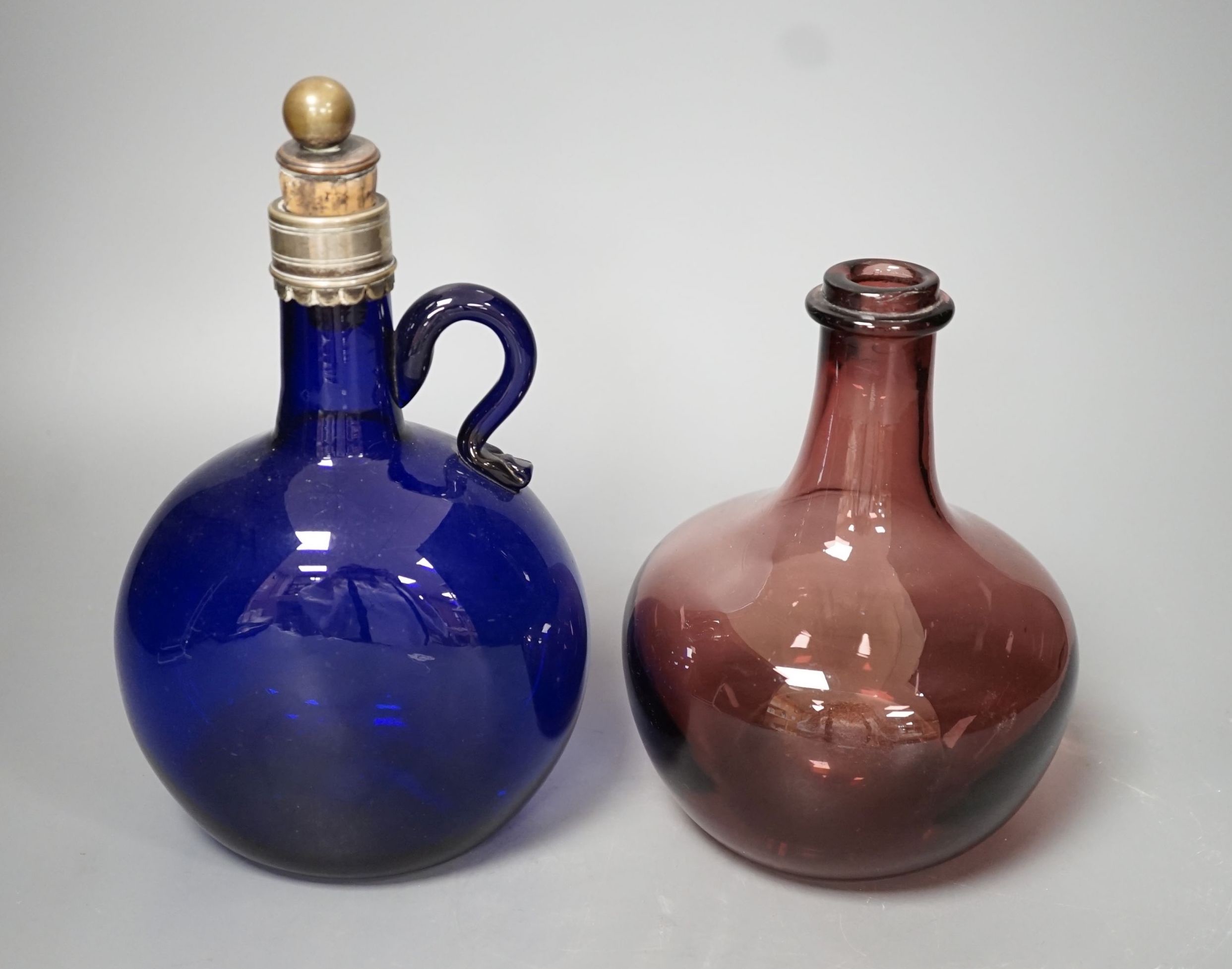 A Victorian blue glass claret jug and an amethyst glass bottle, tallest 23cm